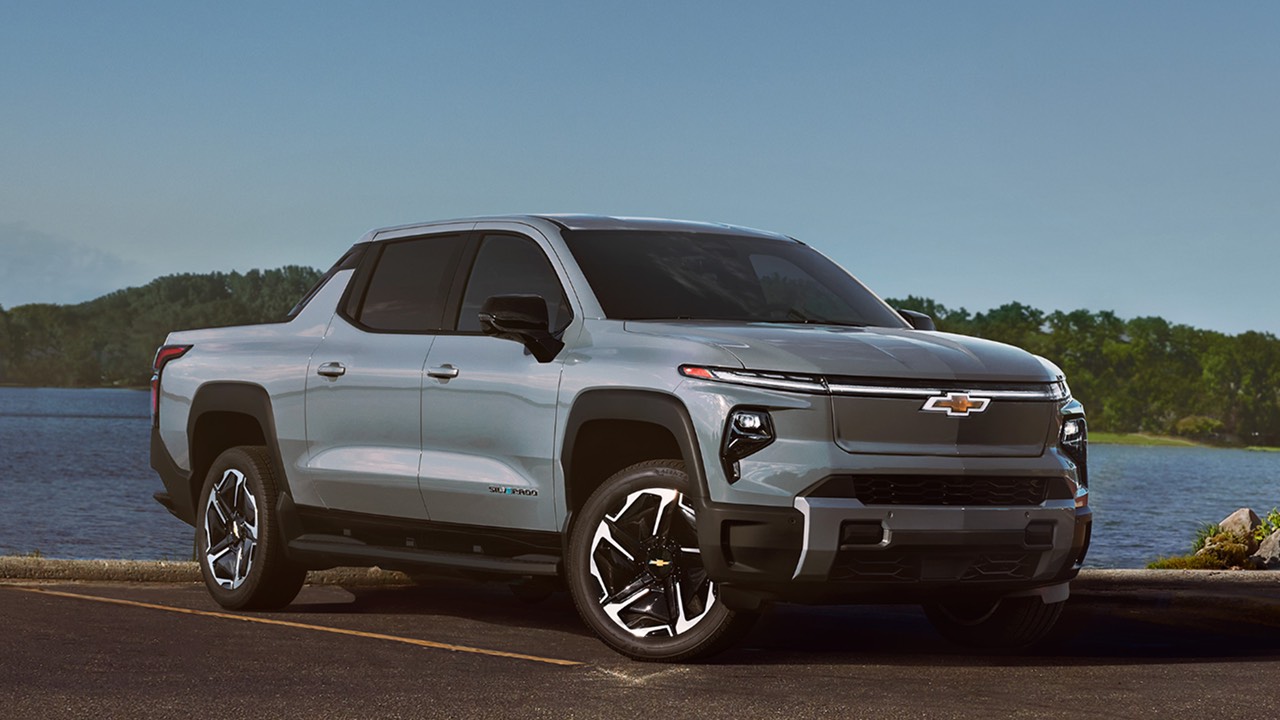 A grey Chevy Silvarado EV parked in front of a lake