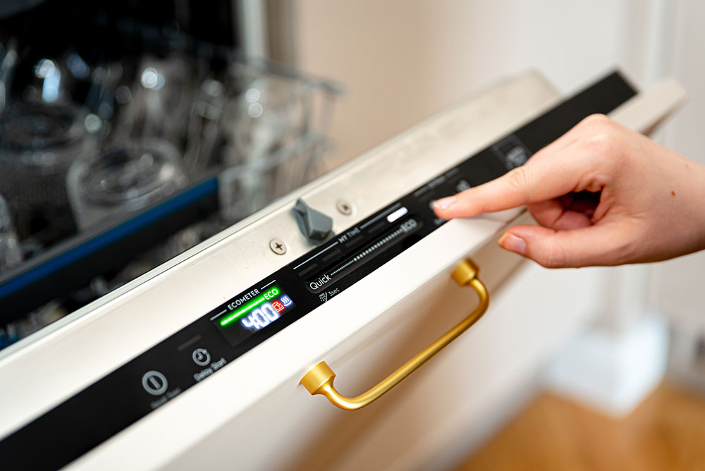 Someone pressing a button on a dishwasher