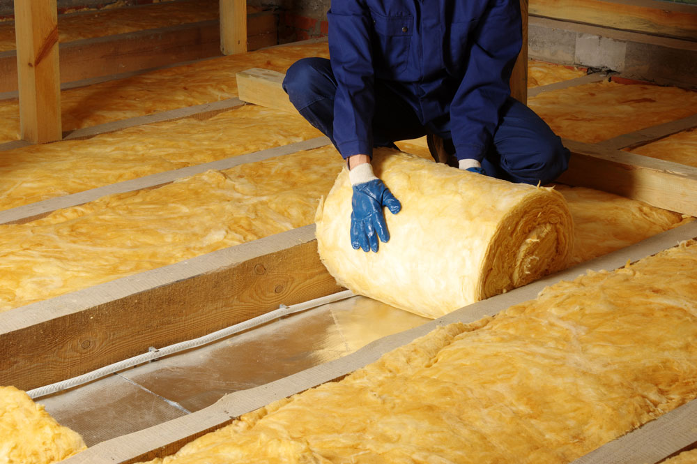 A person rolling out insulation
